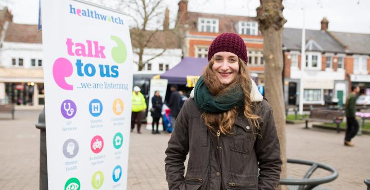 Lady stood next to a Healthwatch banner