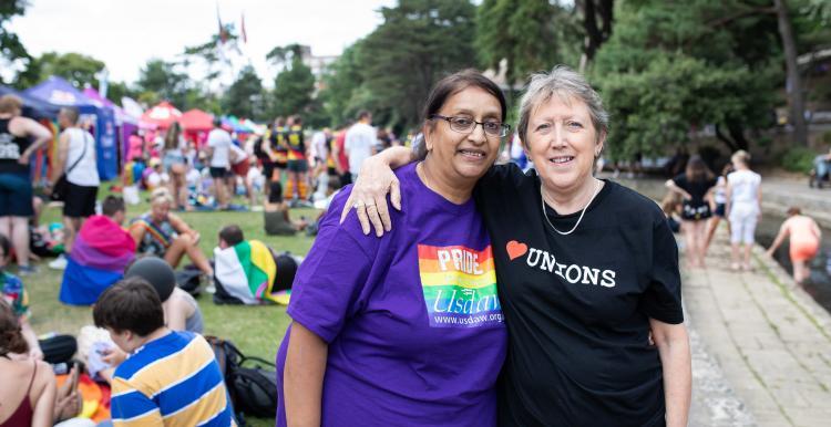 Two women at a Pride demonstration with their arms around each other