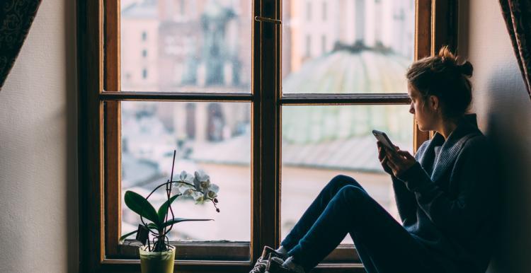 Woman alone at home looking out of the window