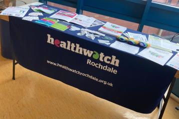 Table with a Healthwatch Rochdale tablecloth and Healthwatch Rochdale publications