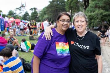 Two women at a Pride demonstration with their arms around each other